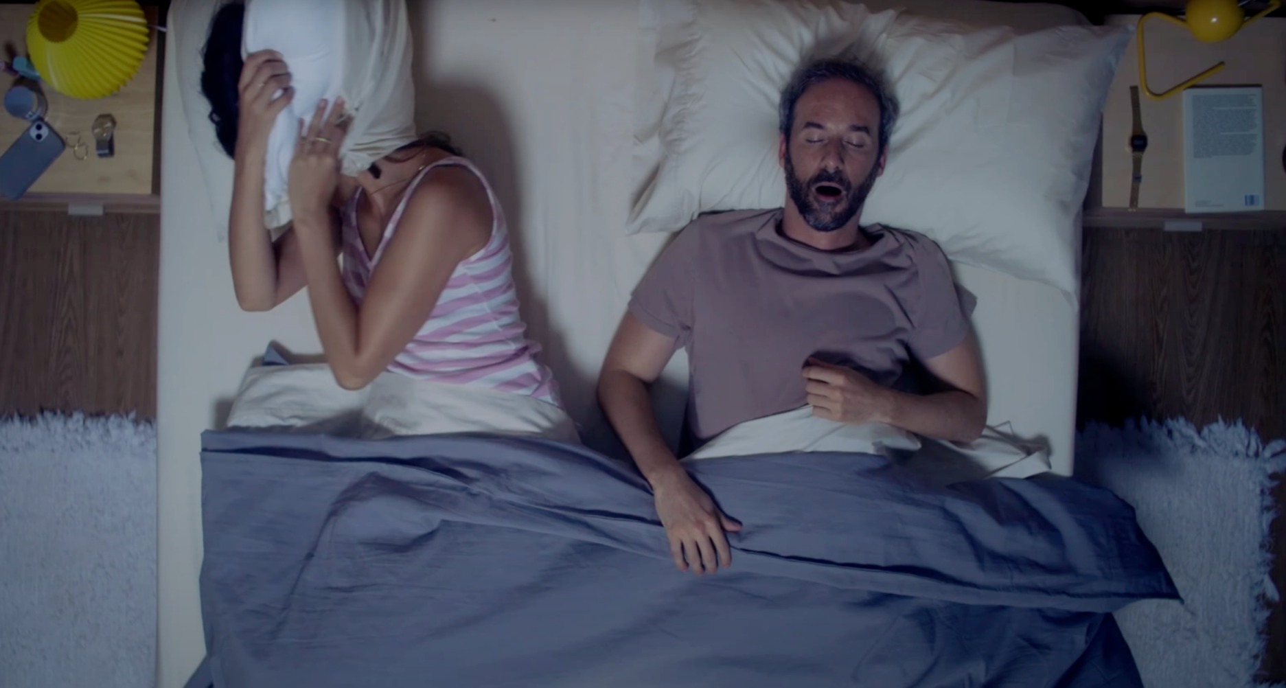 Una pareja durmiendo en la cama. Ella intentándolo y él roncando