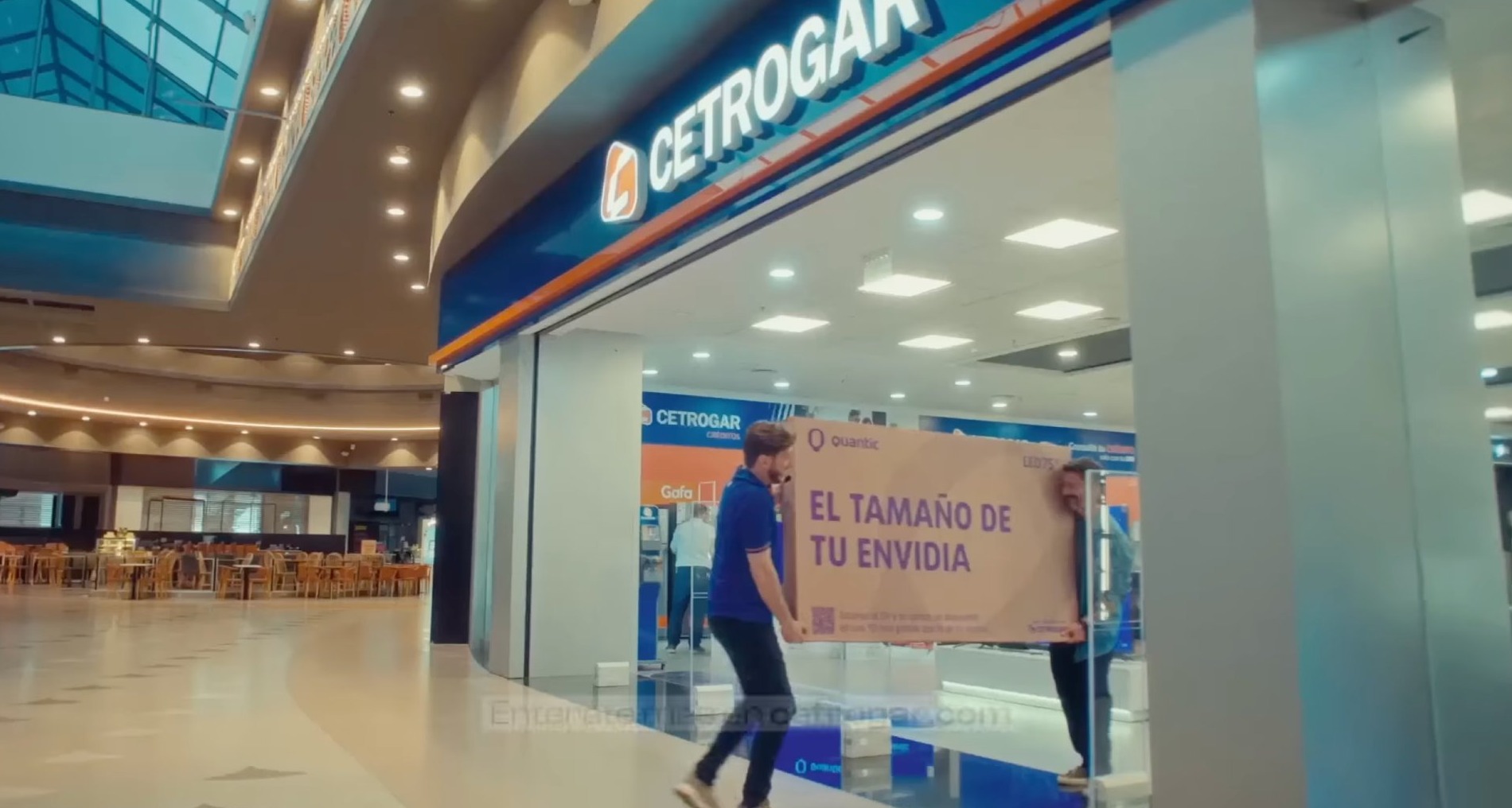 Dos personas sujetan la caja de un televisor saliendo de una tienda de Cetrogar