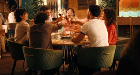 Un grupo de personas brindan en una mesa de restaurante