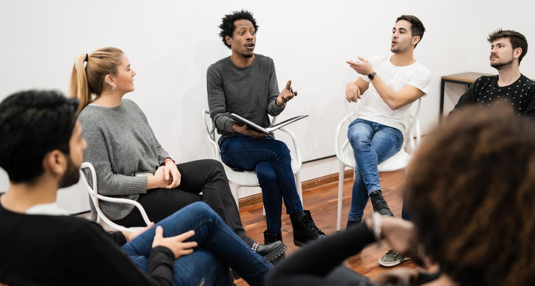 personas debatiendo en un círculo sentados en sillas