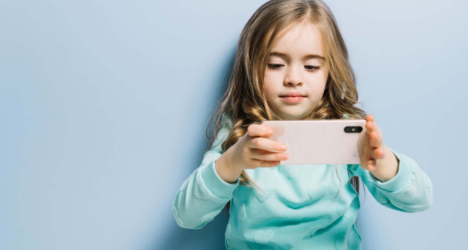 Niña mirando un teléfono móvil