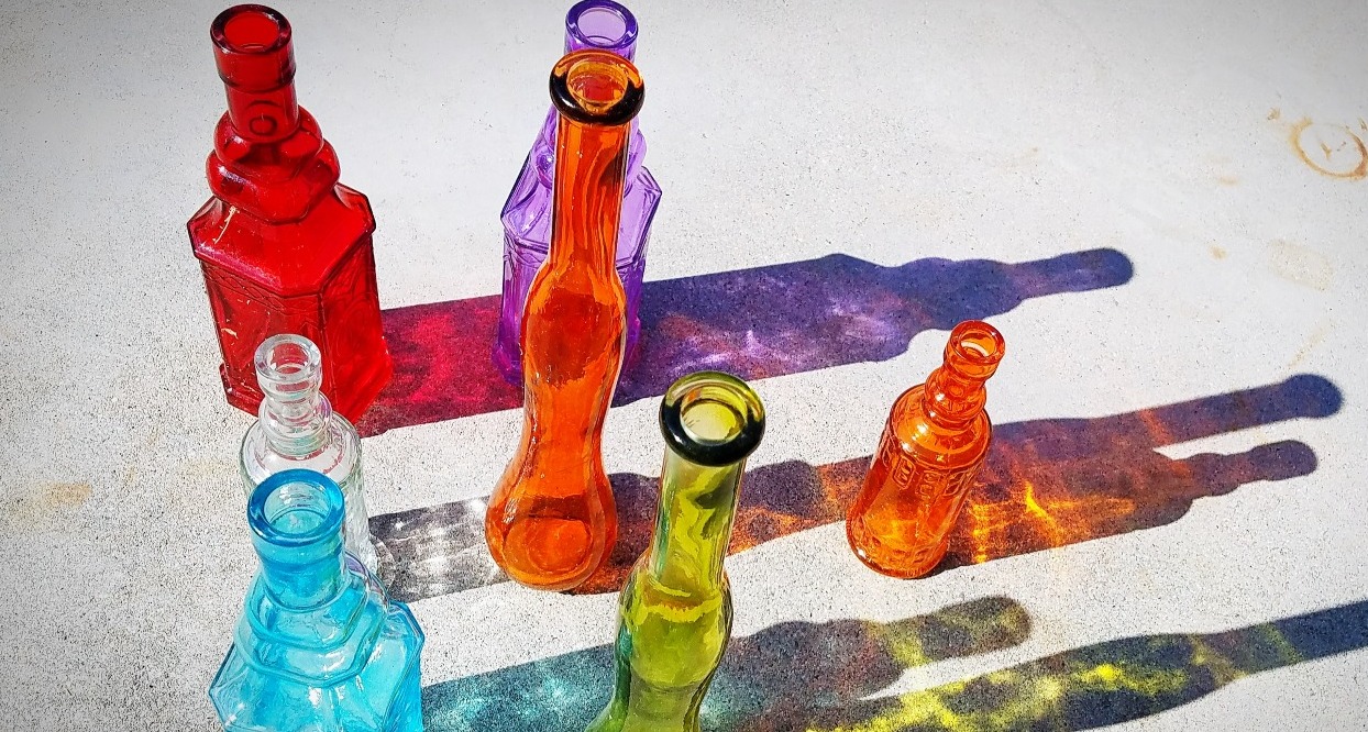 botellas de cristal de colores generando sombras