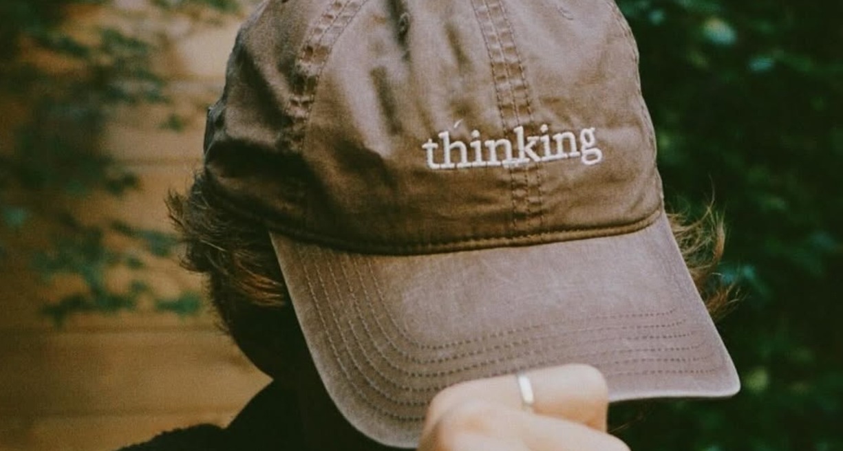 Anthropic convierte un quiosco en un espacio para pensar y reivindica el papel humano en la era de la inteligencia artificial un hombre sosteniendo una gorra marrón en la cabeza donde se puede leer "thinking"