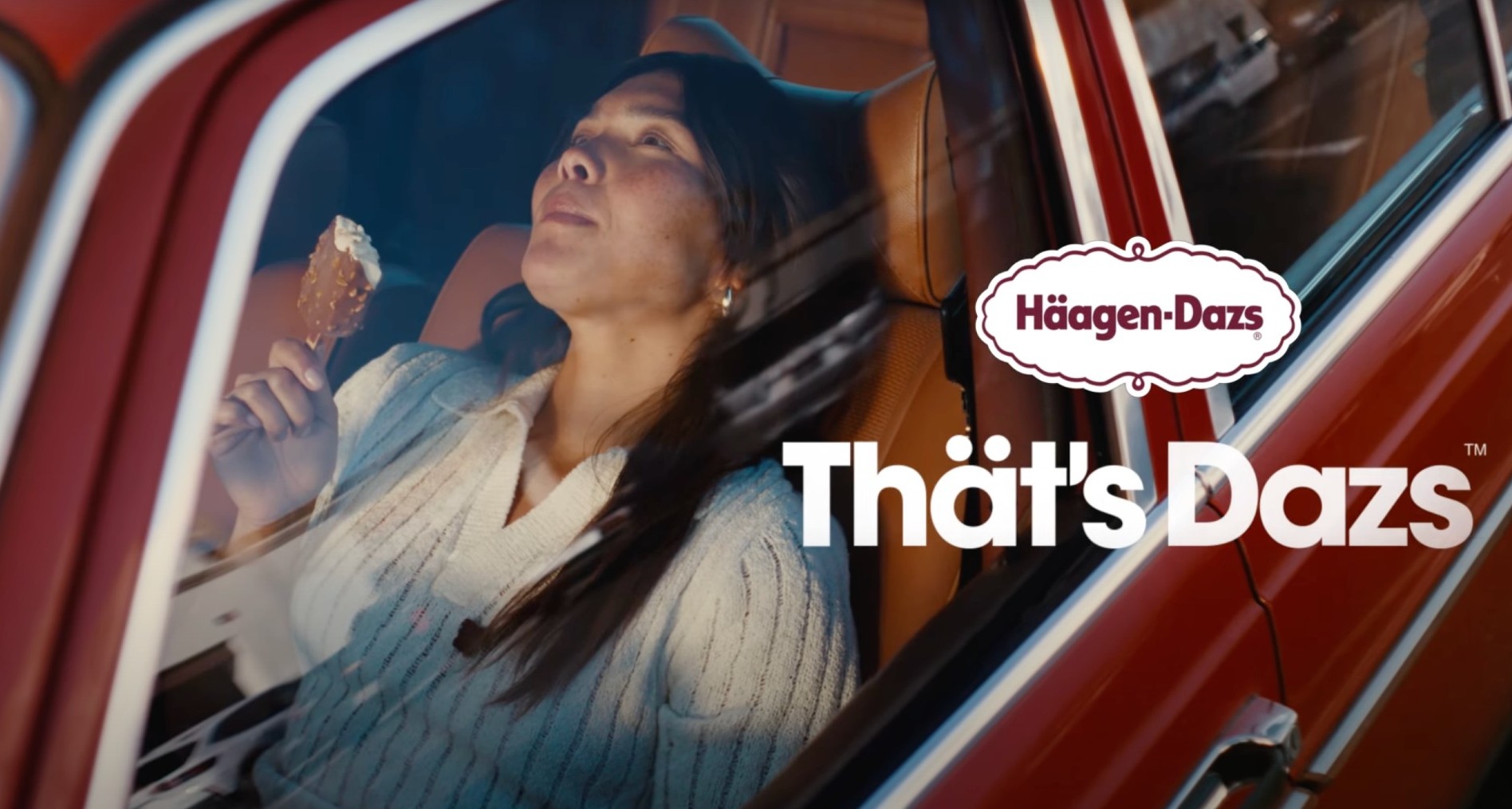 Una chica se come un helado Häagen-Dazs en un coche
