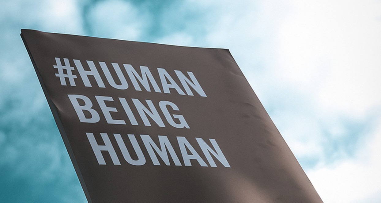 Un cartel en el que se lee Human Being Human