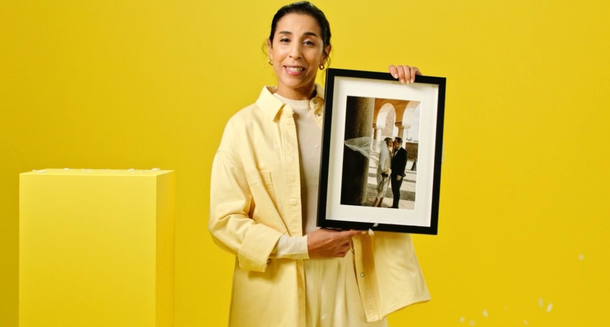 Una mujer enseña un cuadro con la foto de su boda