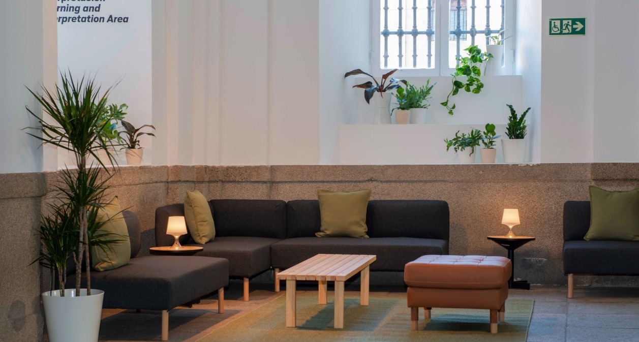 Un espacio común del museo con sillones y mesas de Ikea