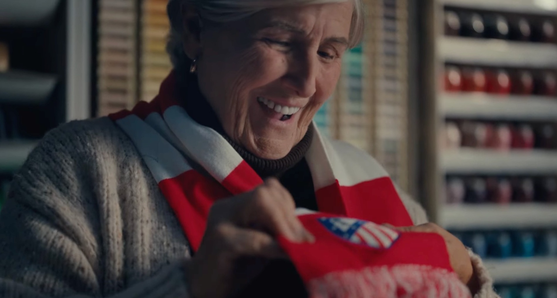 Mujer alegre al recibir una bufanda del Atlético de Madrid