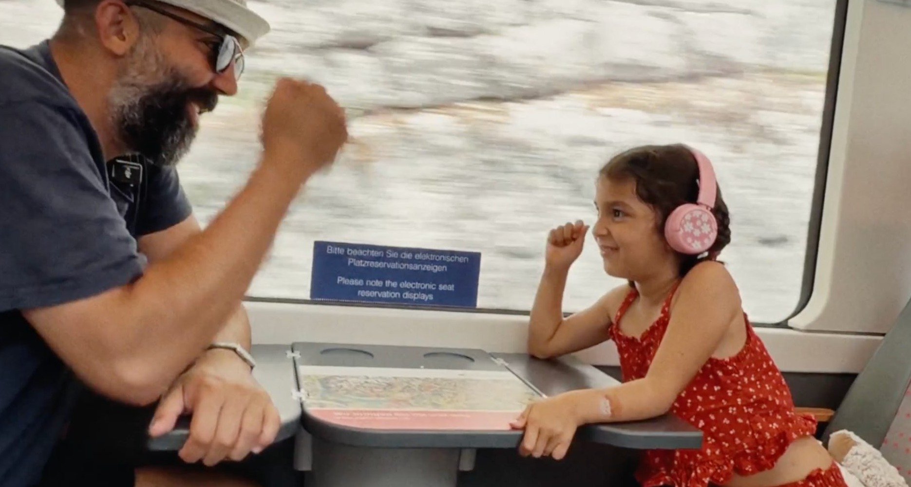 un padre y una hija juegan en un tren