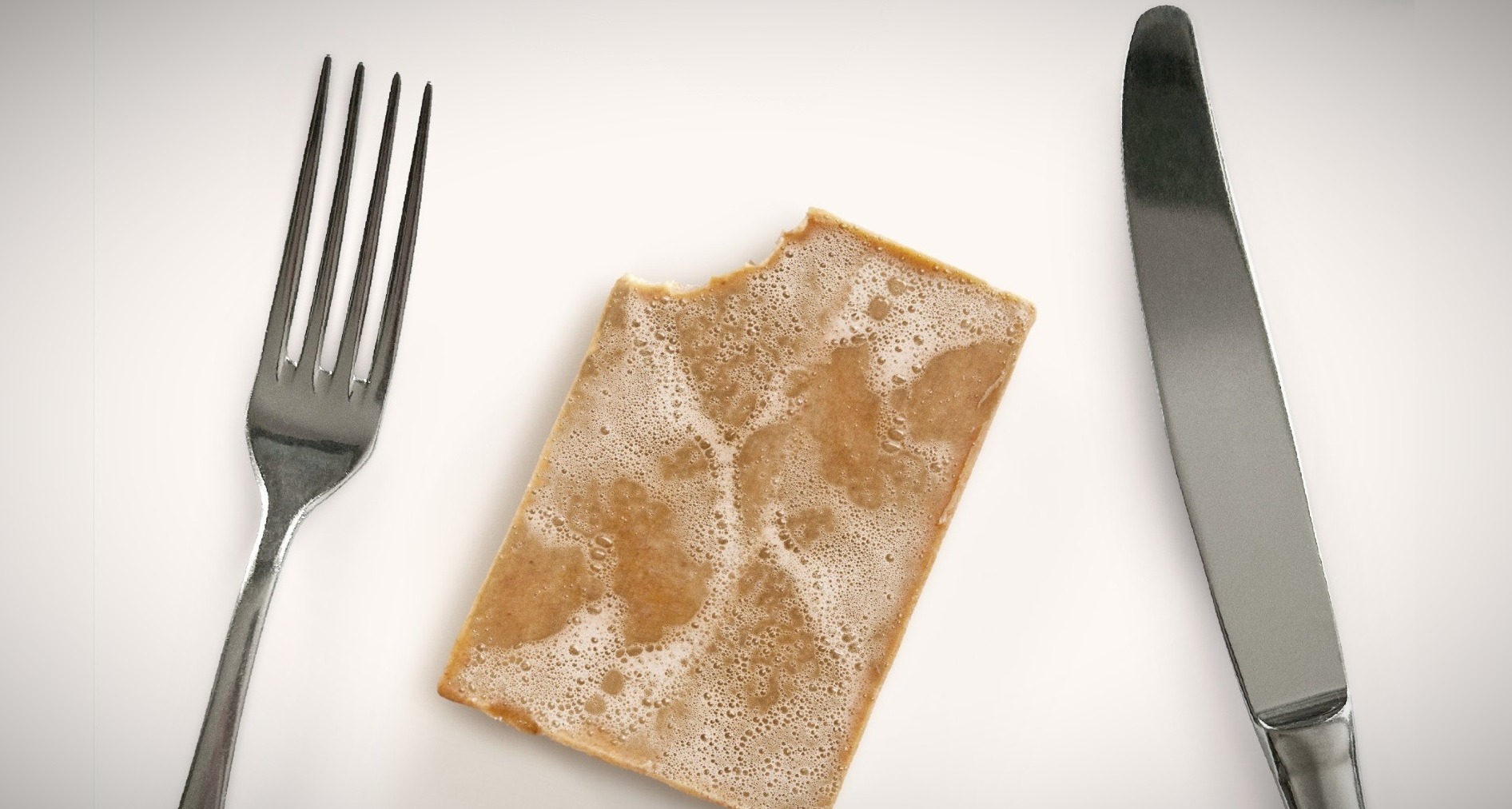Un jabón con un tenedor y un cuchillo a los lados