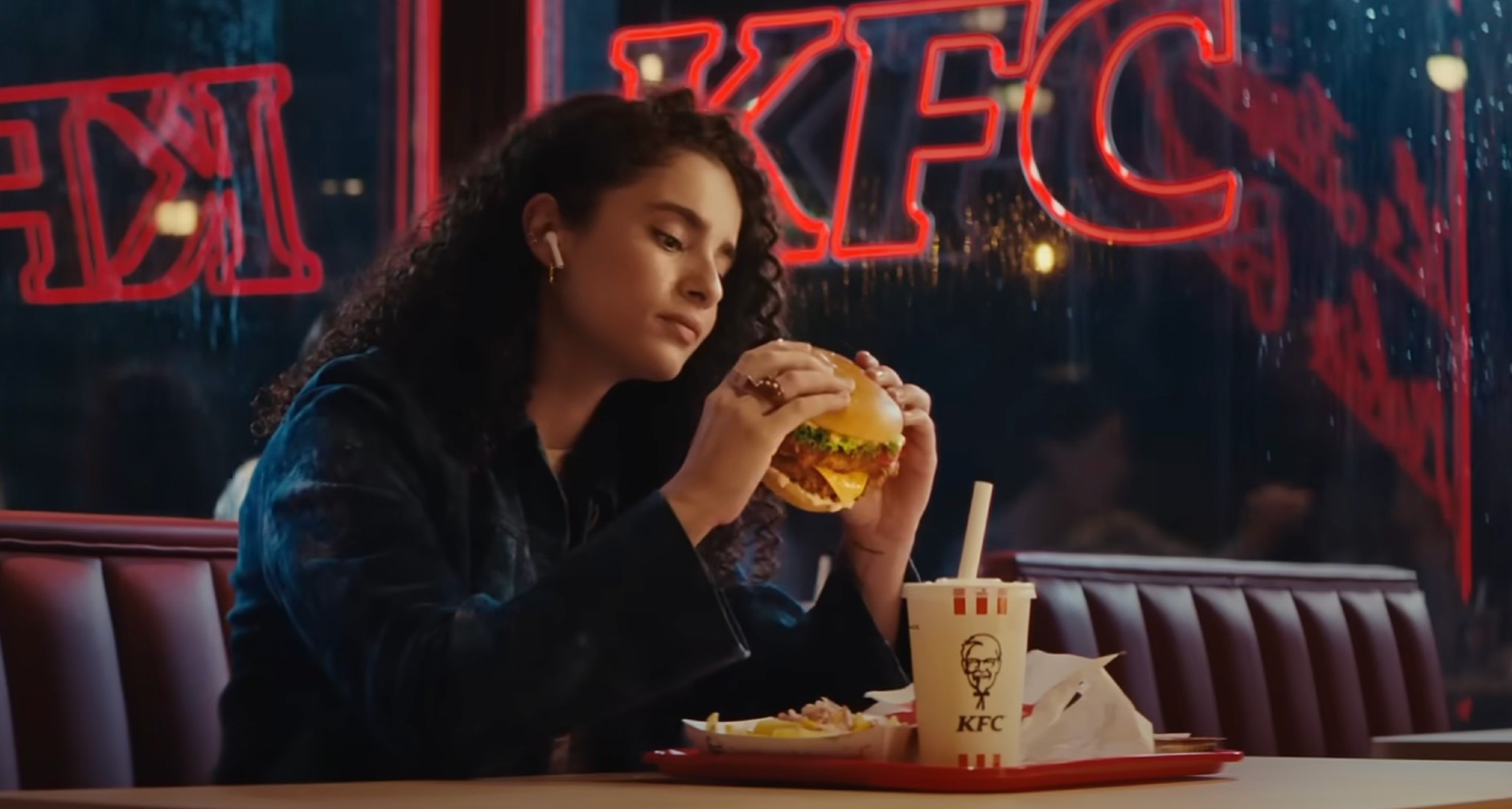 Chica comiendo una hamburguesa en un restaurante KFC