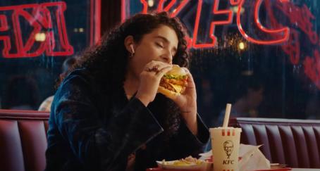 KFC alcanza récord de ventas en España apoyado en la expansión y la estrategia de marketing Chica comiendo hamburguesa kfc