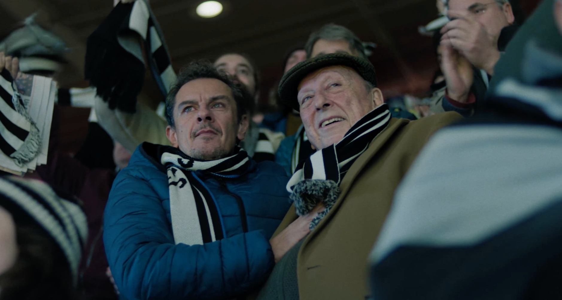 Un padre y un hijo viendo un partido de fútbol en un estadio