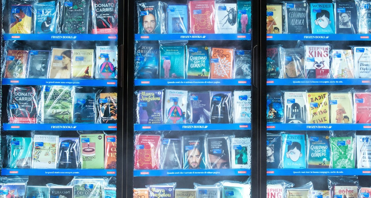 Un congelador de supermercado lleno de libros a modo estantería