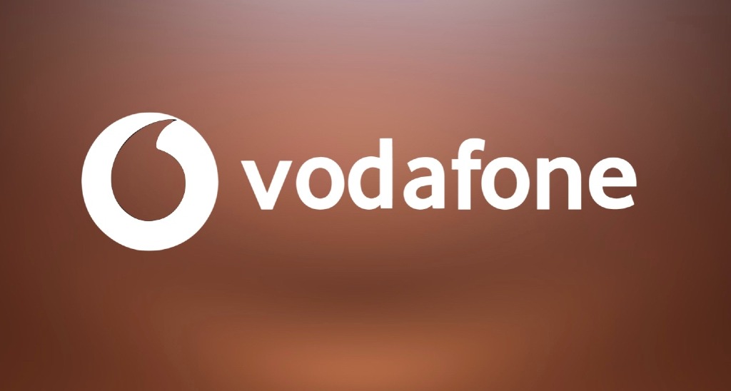 Vodafone activa datos ilimitados e instala redes wifi para ayudar en la emergencia por la dana Logotipo de Vodafone sobre fondo marrón