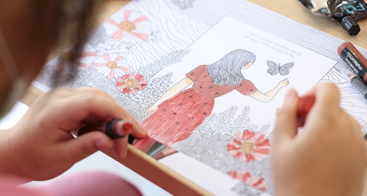 Una niña pintando un dibujo con labiales de L'Oréal