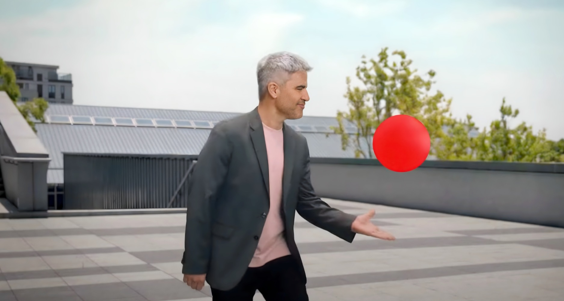 Ernesto Sevilla mirando hacia el punto rojo e Lowi en una terraza