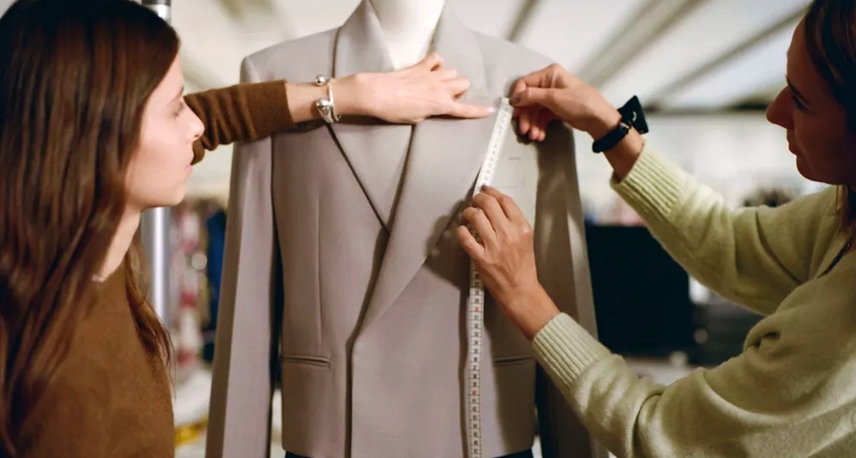 Dos mujeres tomando medidas a una americana colocada en un maniquí