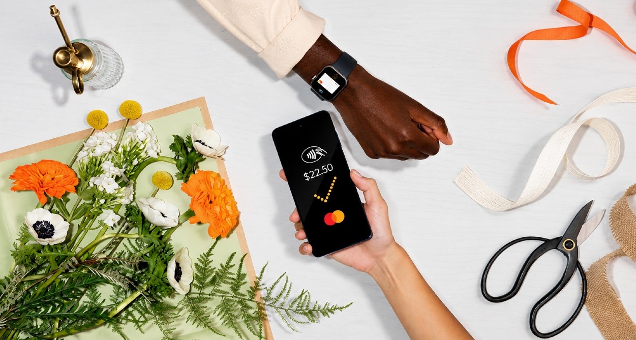 Una mano pagando con el teléfono a través de Mastercard