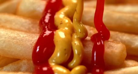 Mostaza y ketchup sobre patatas fritas formando bandera de España