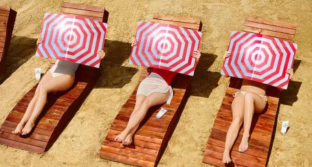 Mujeres sujetan un reflector invertido en la playa