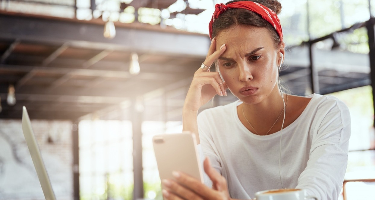 Una chica mira el teléfono con cara de preocupación