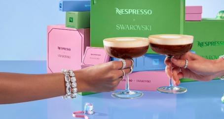 Dos manos con joyas brindando en copas con café