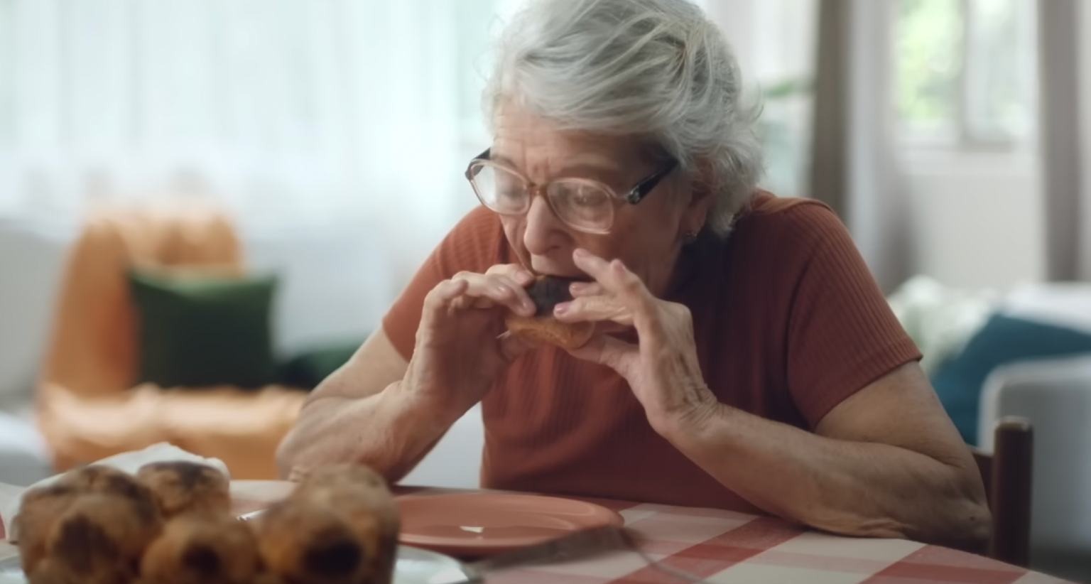 Mujer mayor come un pedazo de pastel con las manos