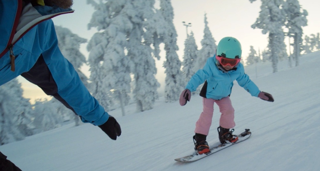 Una niña haciendo snowboard
