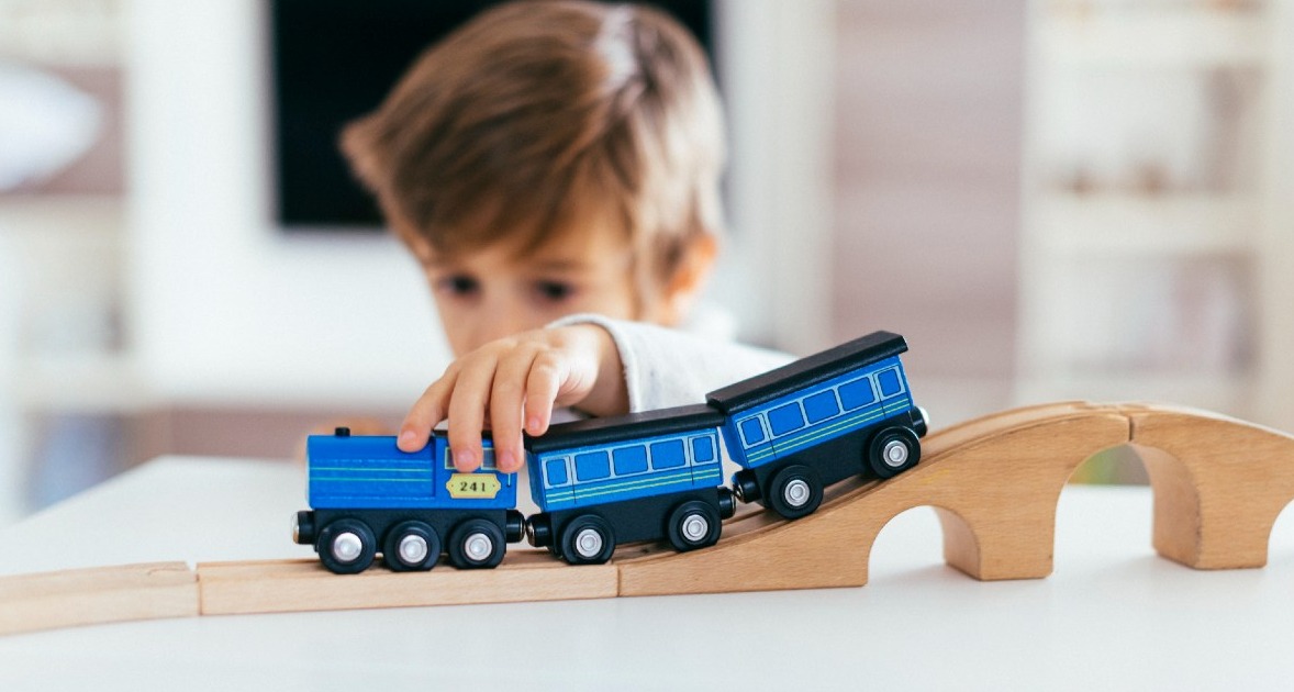 niño jugando con un trenecito