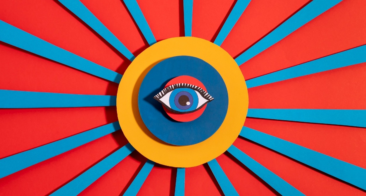 Un collage de colores con un ojo en el centro y líneas rojas y azules hacia los extremos