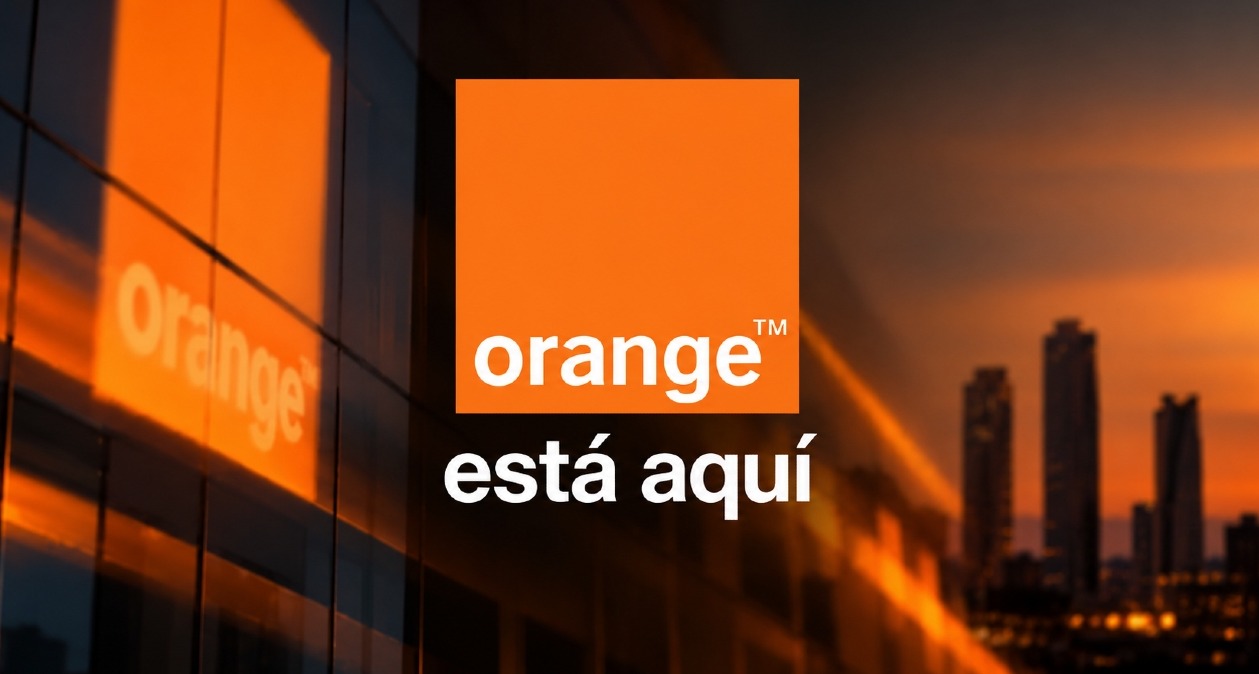 El logotipo de Orange sobre un fondo de ciudad al atardecer