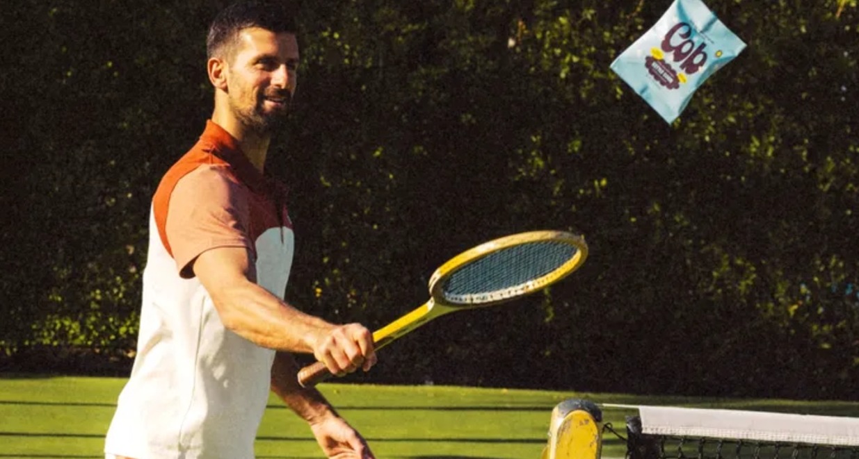 Novak Djokovic levantando una bolsa de Cob con una raqueta antigua de tenis