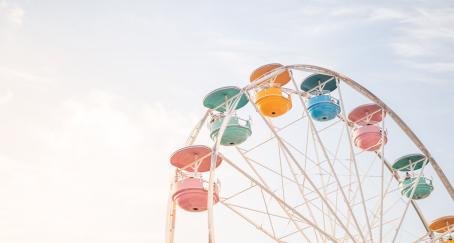 Atracción de noria con cabinas de colores sobre cielo azul para representar parques de atracciones