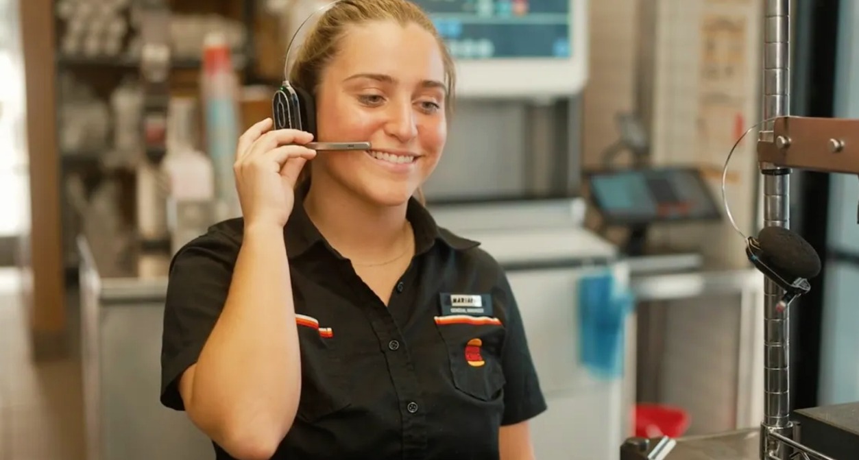 Una empleada de Burger King colocándose el micrófono de los auriculares
