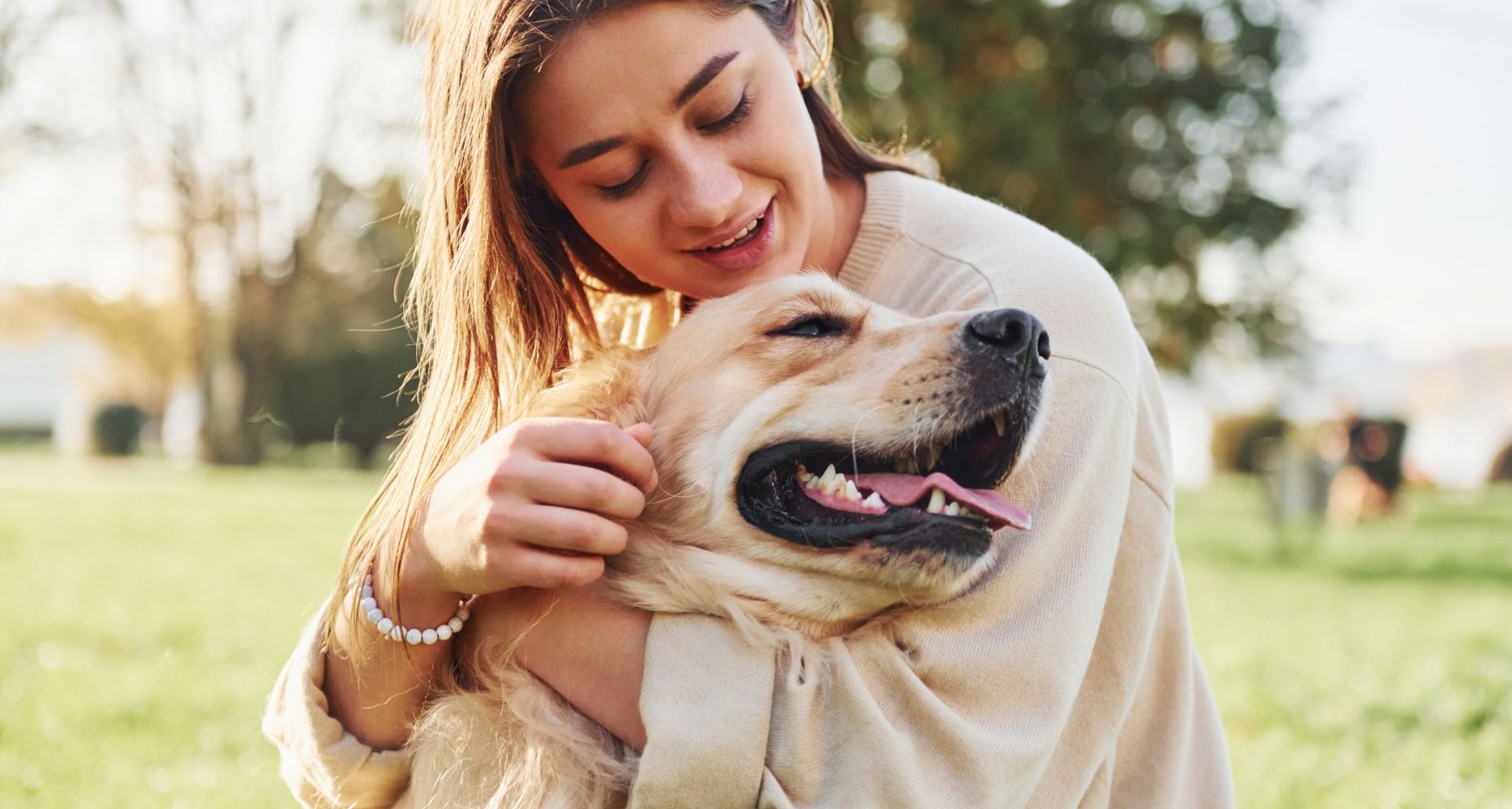 Chica joven abraza a su perro en un parque