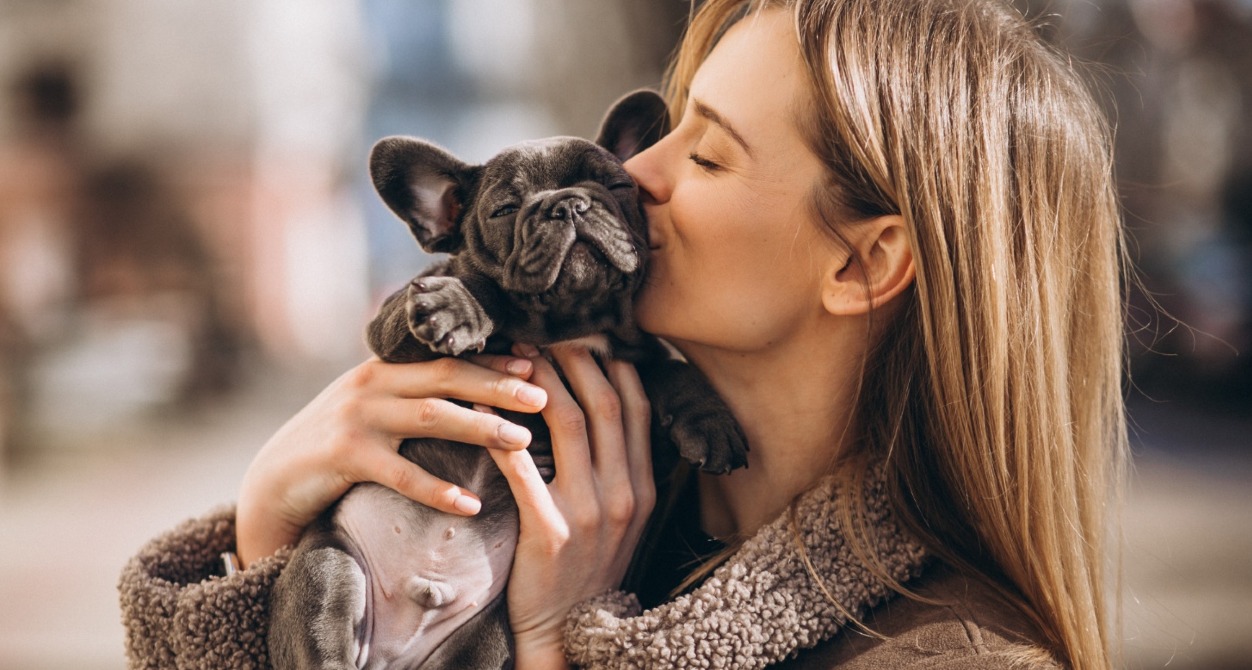 una chica abrazando y dando un beso a su perro