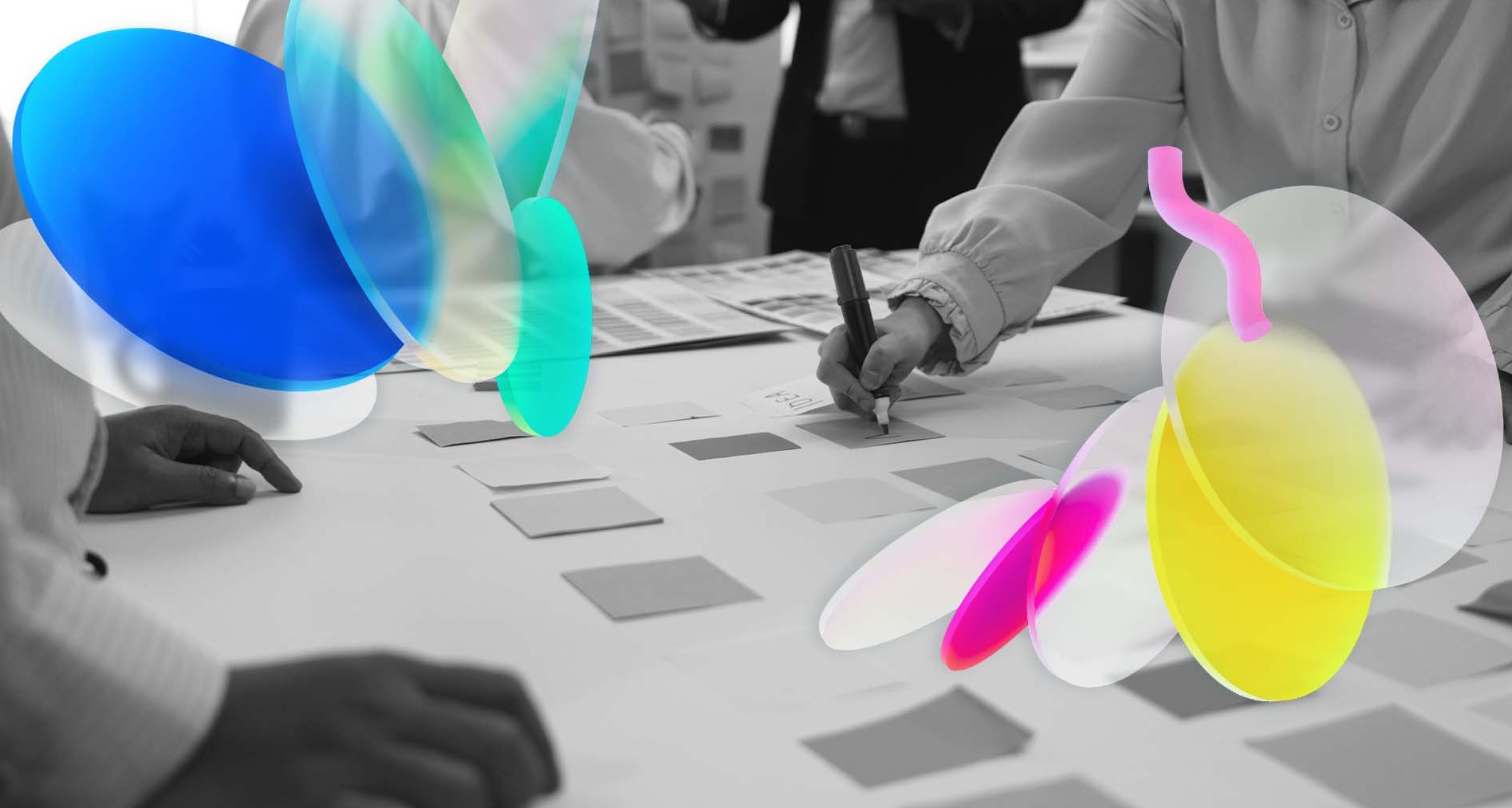 unas manos escribiendo y dibujando en una mesa colaborativa