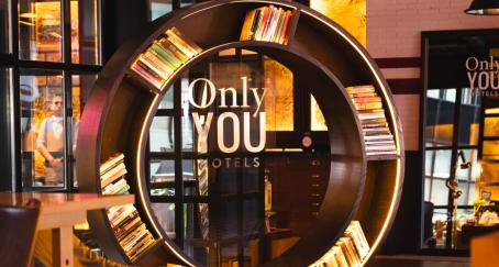 estantería de Only You Hotels, con forma circular y luces led integradas, en un espacio común de uno de sus hoteles.