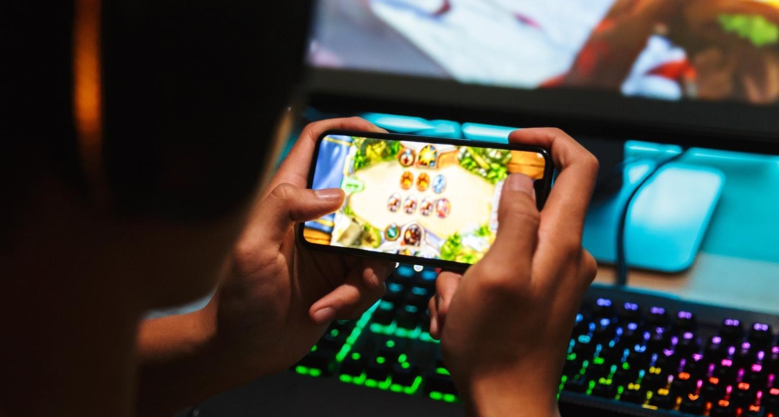 La publicidad en videojuegos: oportunidades y desafíos de un ecosistema favorable y aún por explorar Joven jugando a un videojuego en el móvil