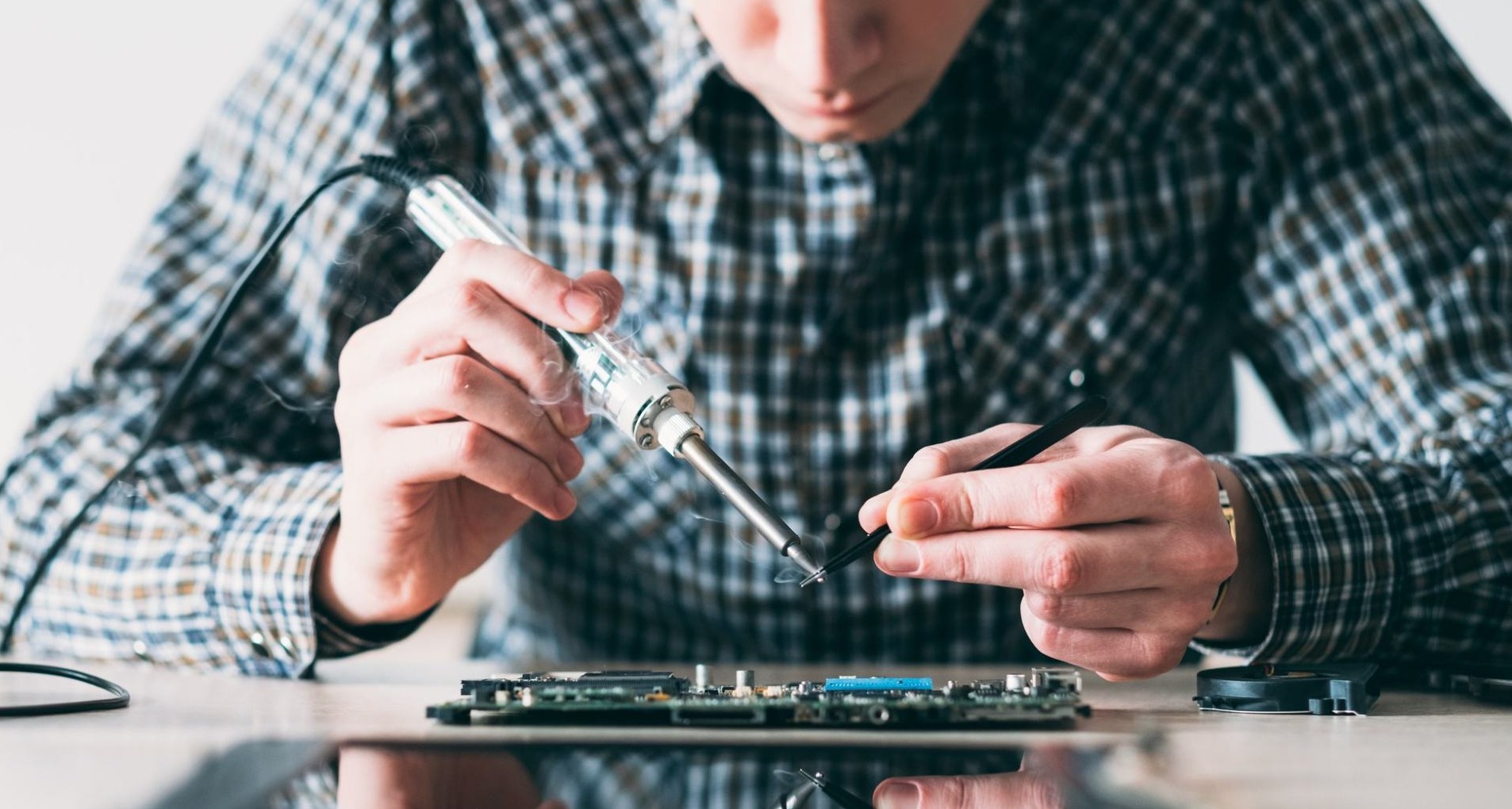Joven reparando un teléfono