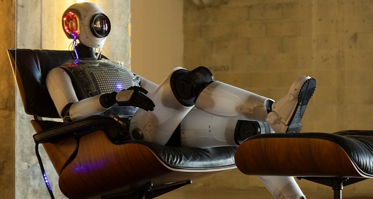 un robot sentado en un sillón viendo la televisión