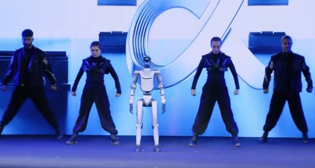 El robot de Honor sobre el escenario rodeado de bailarines humanos