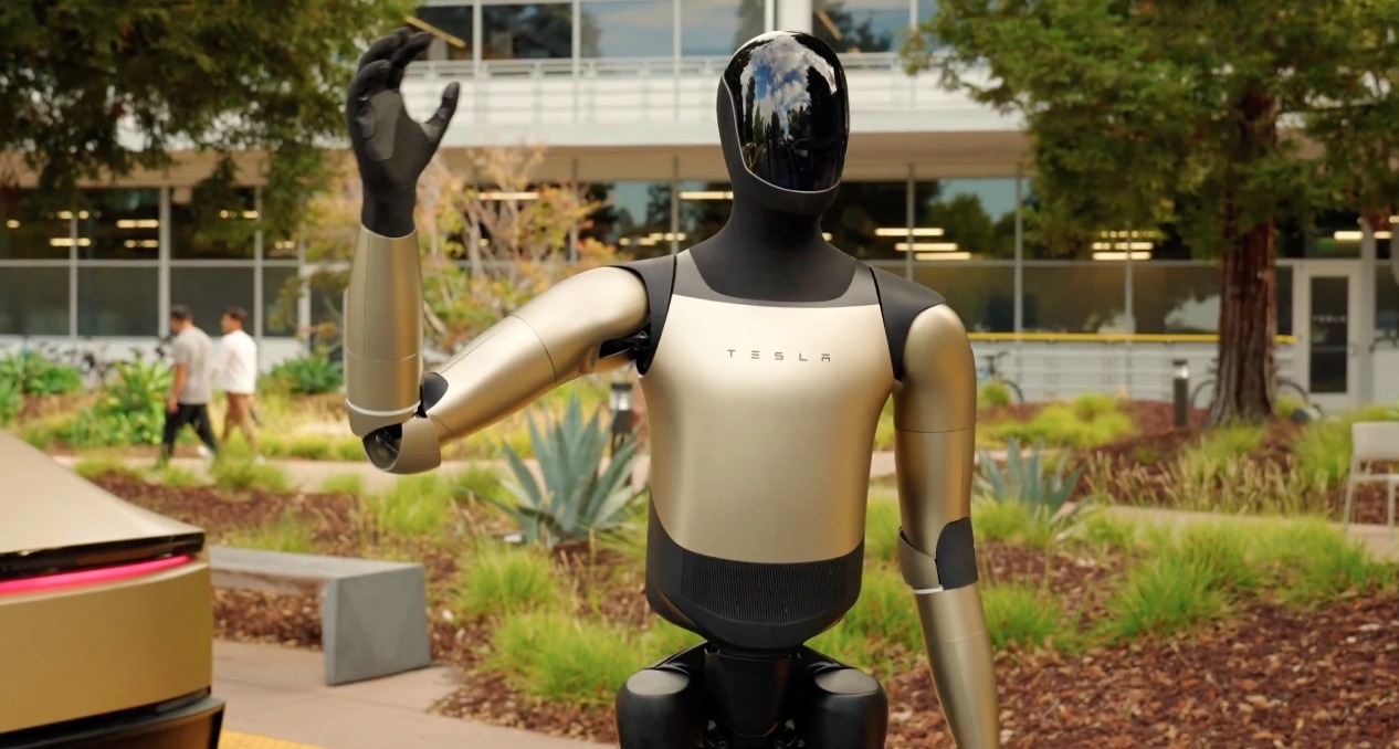 El robot Optimus de Tesla saludando en un jardín