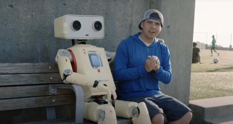 Un robot-cámara de Sandisk junto a un creador de contenido