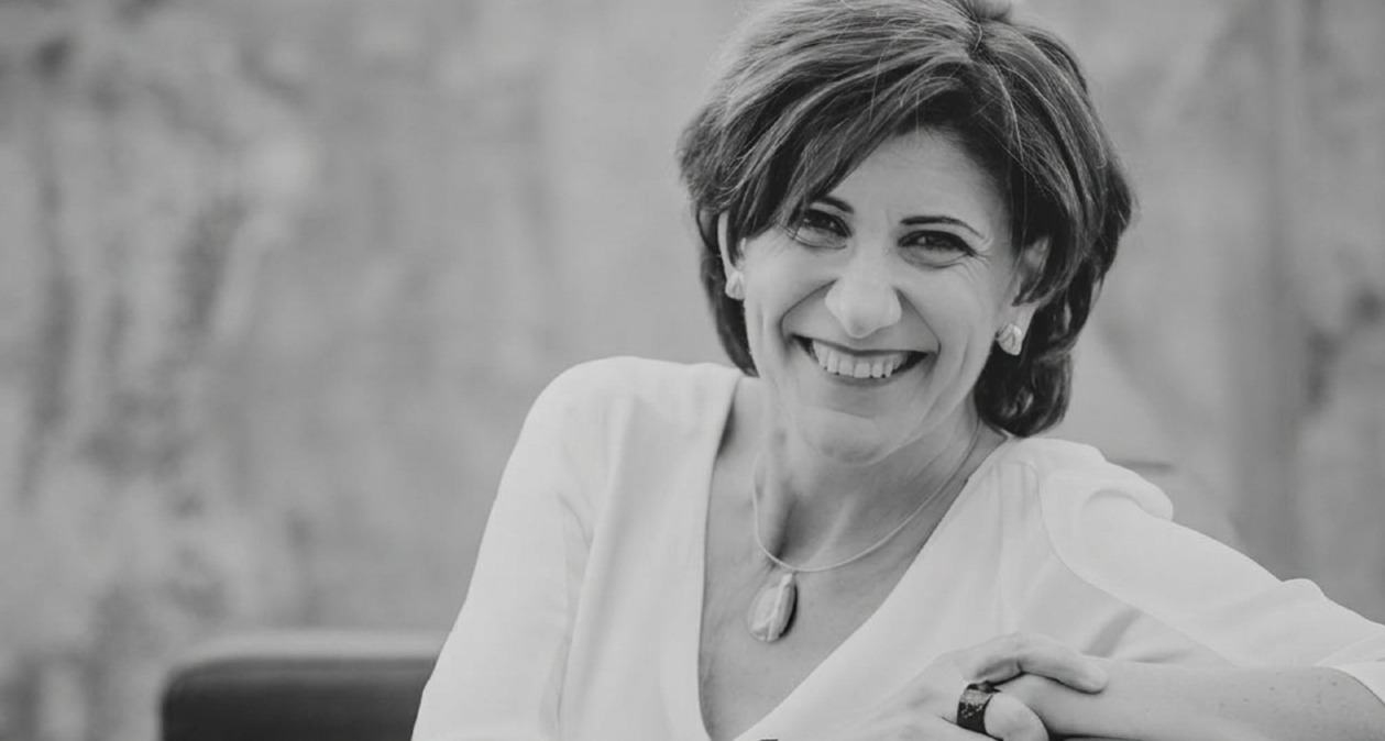 Foto en blanco y negro de Sara Blázquez sonriendo sentada en una butaca