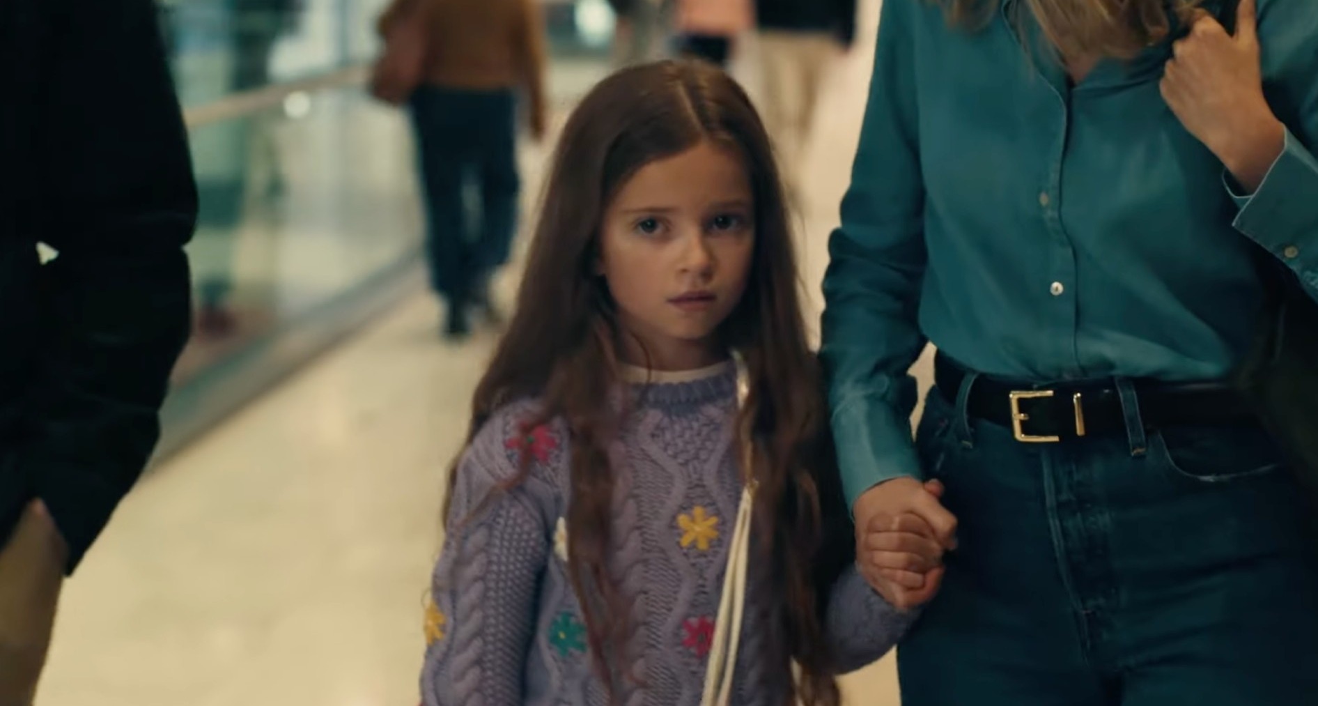 Una niña asustada coge la mano de su madre