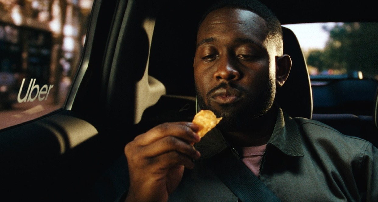 Un hombre a punto de comerse una patata crujiente en el coche