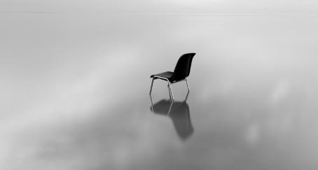 Una silla en un paisaje vacío en blanco y negro