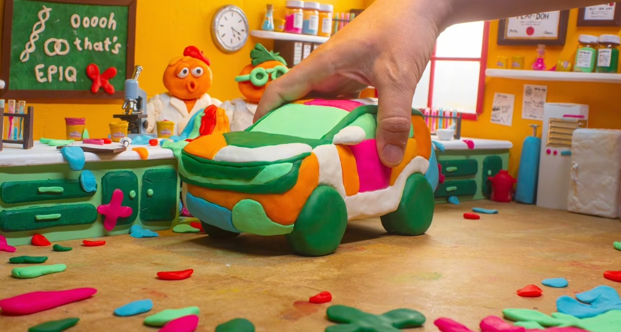 Una mano cogiendo un coche hecho con Play-Doh